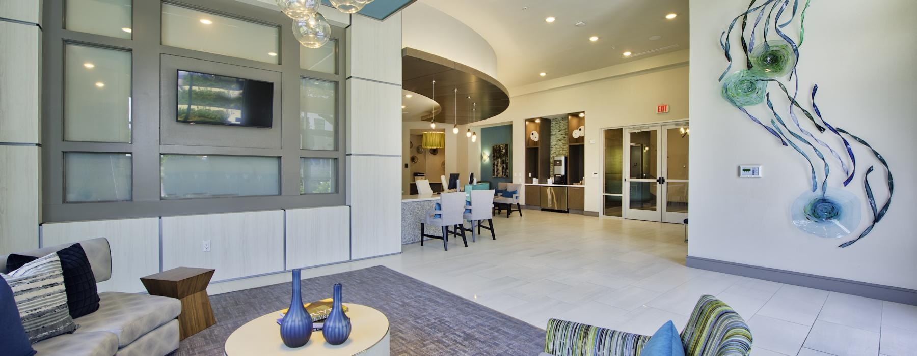 a large clubhouse room with a chandelier and seats