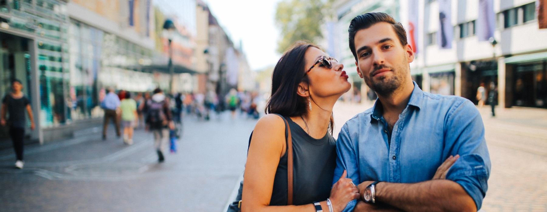 a man and woman posing for a picture on a street